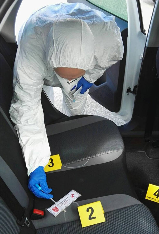 Un agente recoge muestras en un vehículo