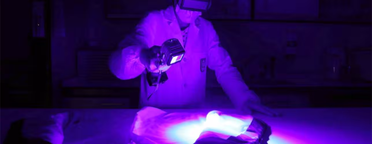 Selene Rol, especialista en ADN de la Policía Foral, examina una prenda con la luz forense.